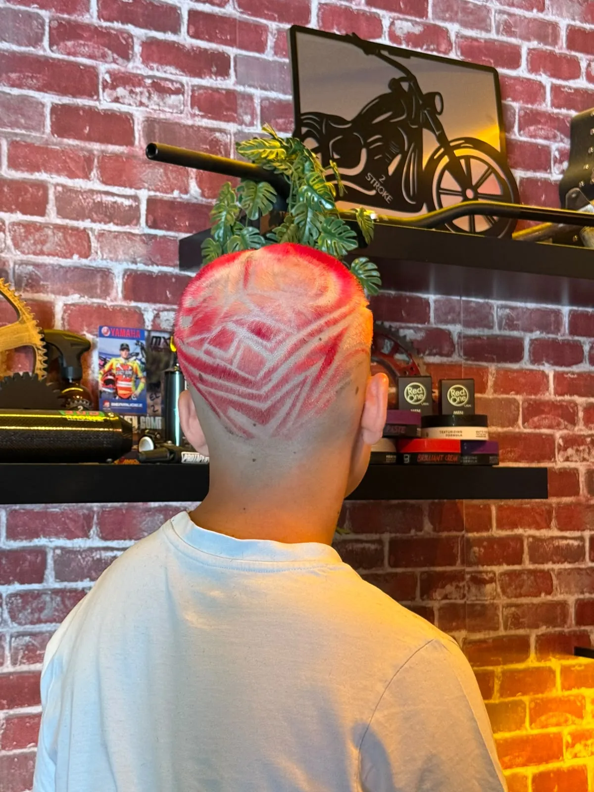 Diseño rasurado con color rojo en la nuca, trabajo de 2 Stroke Barbershop en Fuenlabrada