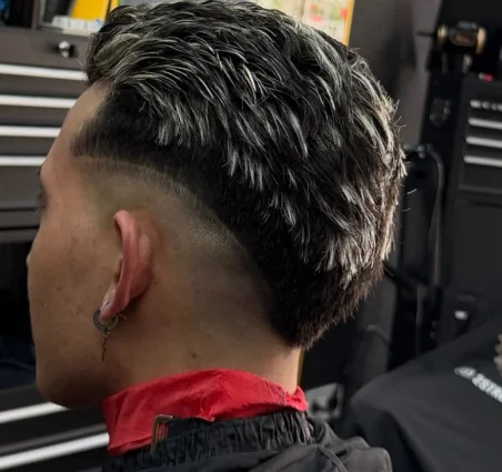 Mechas rubias con skin fade alto y pelo texturizado visto de espaldas, trabajo de 2 Stroke Barbershop en Fuenlabrada