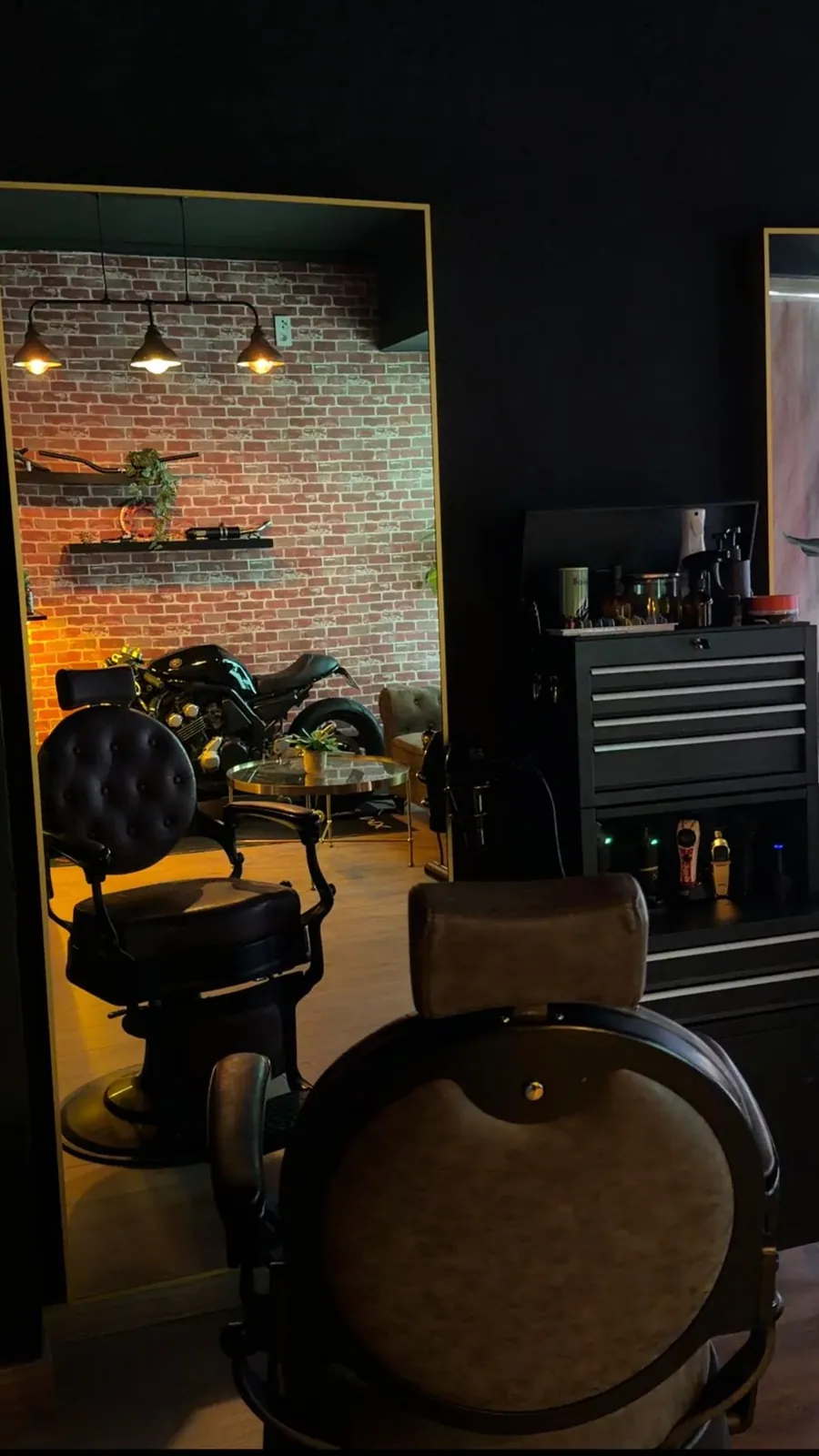 Sillones de barbero y espejos grandes con marco dorado en 2 Stroke Barbershop